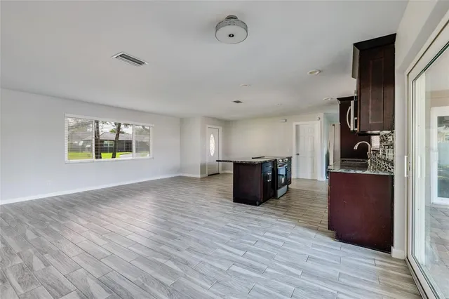 a view of kitchen with wooden floor electronic appliances and window