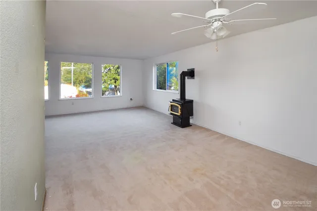 an empty room with windows and view of chandelier