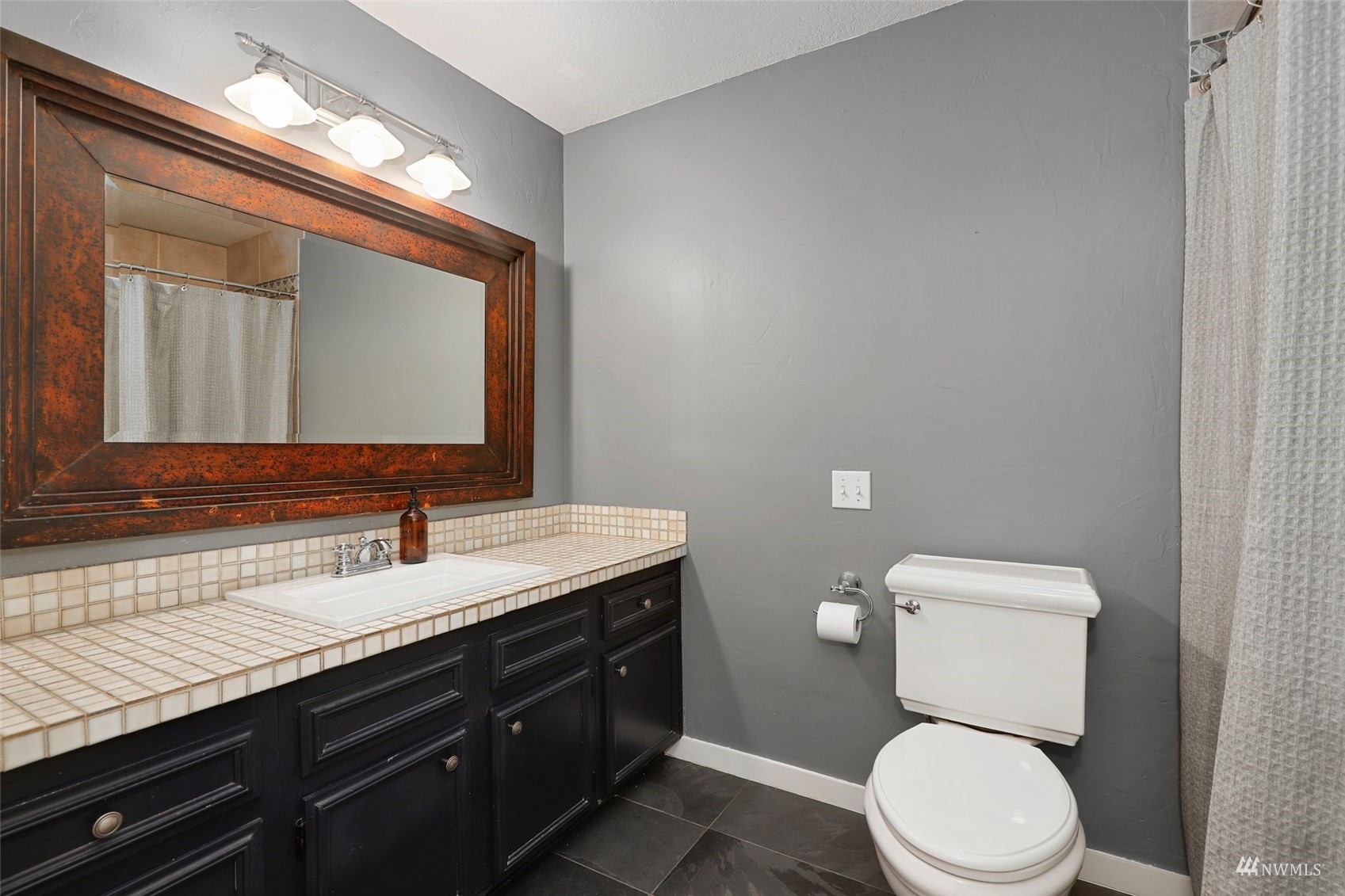 24301 23rd Avenue West Bothell, WA 98021 - Photo 25 of 39 a bathroom with a granite countertop toilet sink and mirror