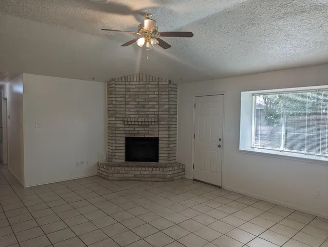 an empty room with windows and fireplace
