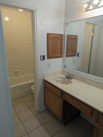 a bathroom with a granite countertop sink a toilet and shower