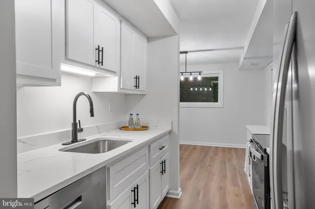 a kitchen with stainless steel appliances a sink stove and refrigerator