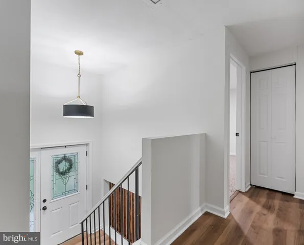 a view of a hallway with wooden floor and stairs