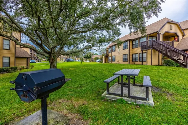 a view of a house with backyard and a sitting area