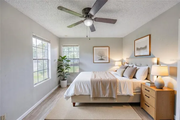 a bedroom with a bed and a chandelier fan