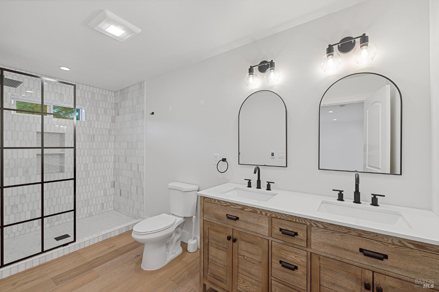 19129-19131 Spring Drive Sonoma, CA 95476 - Photo 12 of 29 a bathroom with a double vanity sink toilet and a mirror