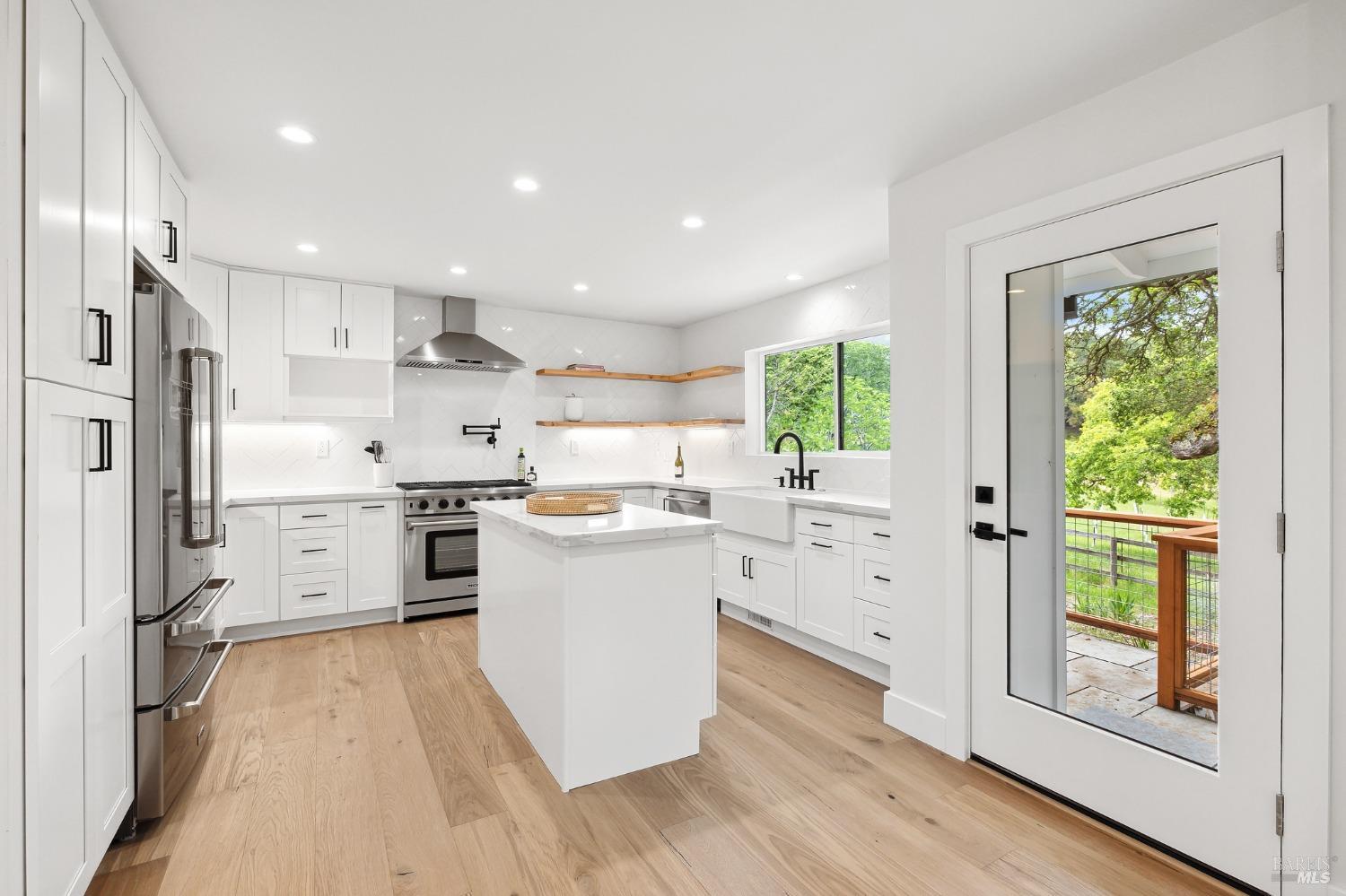 19129-19131 Spring Drive Sonoma, CA 95476 - Photo 8 of 29 a kitchen with white cabinets and wooden floors