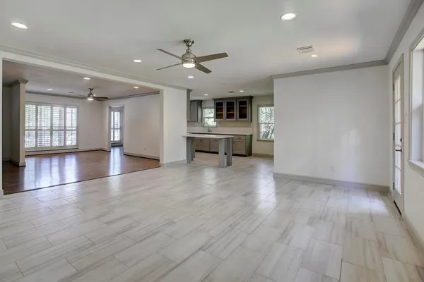 a view of a livingroom with furniture wooden floor a ceiling fan and windows