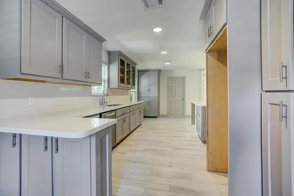 a kitchen with cabinets and wooden floor