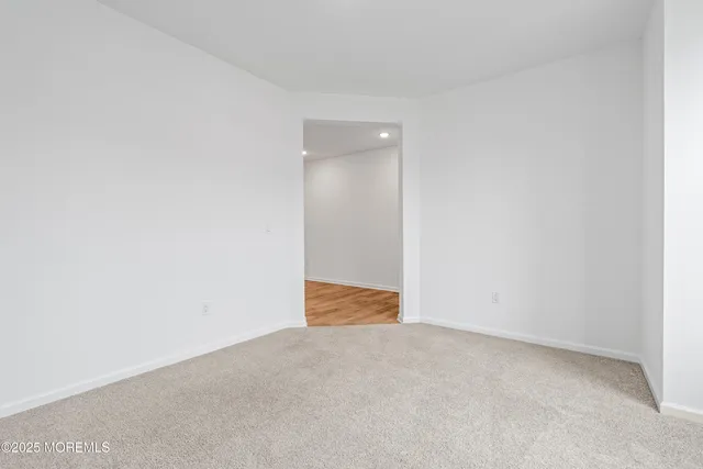 an empty room with wooden floor fireplace and windows