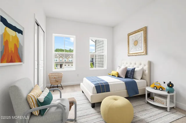 a large white bed sitting in a bedroom next to a window with a dresser