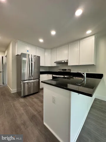 a modern kitchen with stainless steel appliances granite countertop a sink a stove a refrigerator and cabinets