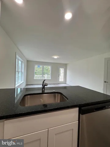 a kitchen that has a sink and a stove with white countertops