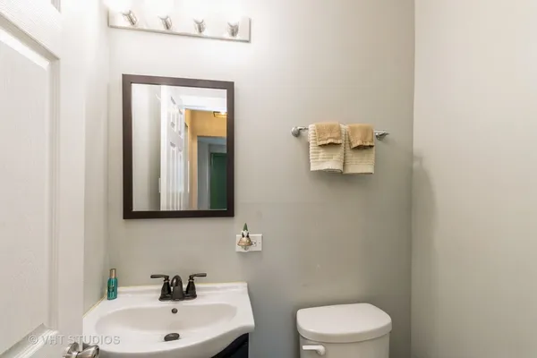 a bathroom with a toilet a sink and mirror