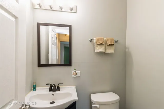 a bathroom with a toilet a sink and mirror