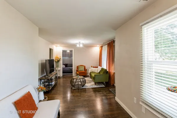 a living room with fireplace furniture and a large window