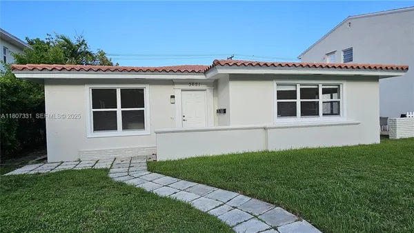 a front view of a house with a garden