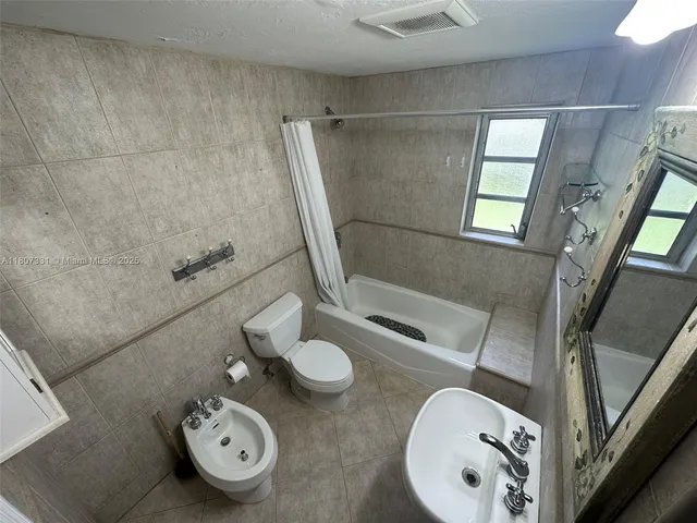a bathroom with a sink mirror and toilet