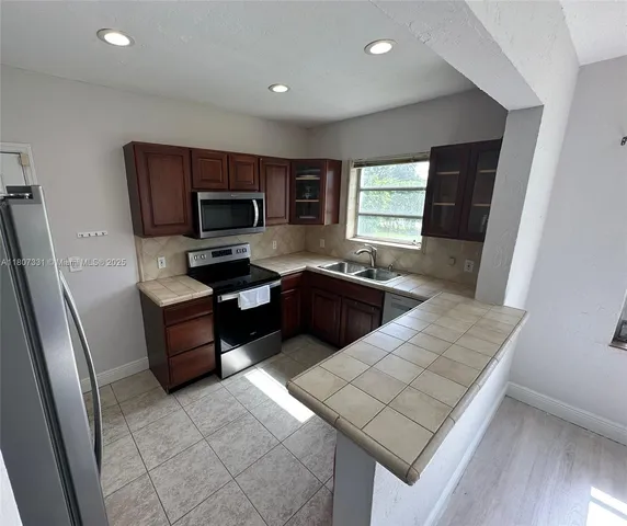 a kitchen with granite countertop a stove refrigerator and sink