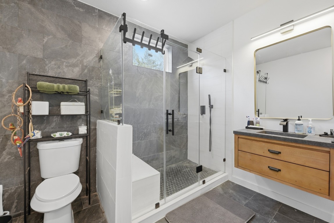 25504 Squirrel Road New Ulm, TX 78950 - Photo 15 of 37 a bathroom with a toilet sink vanity granite and shower