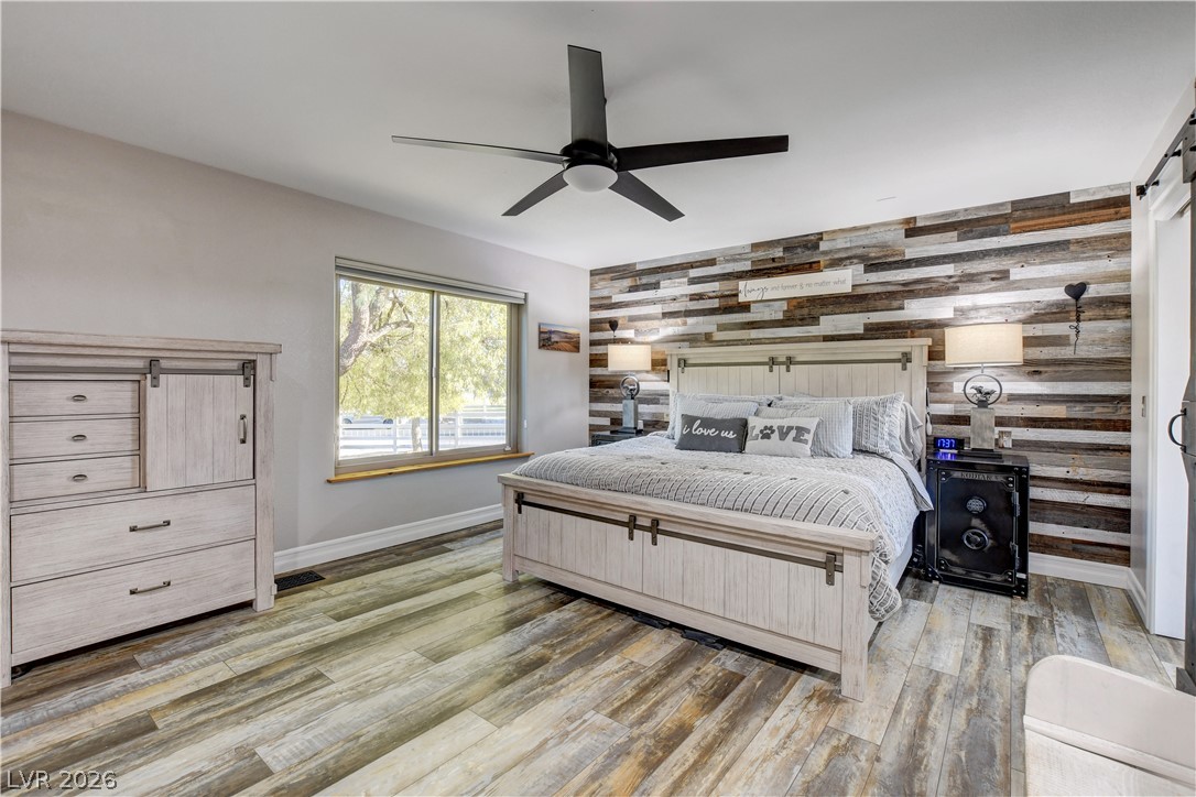 6460 Racel Street Las Vegas, NV 89131 - Photo 40 of 59 Textured flooring and a rustic wood plank accent wall create a cozy bedroom atmosphere.