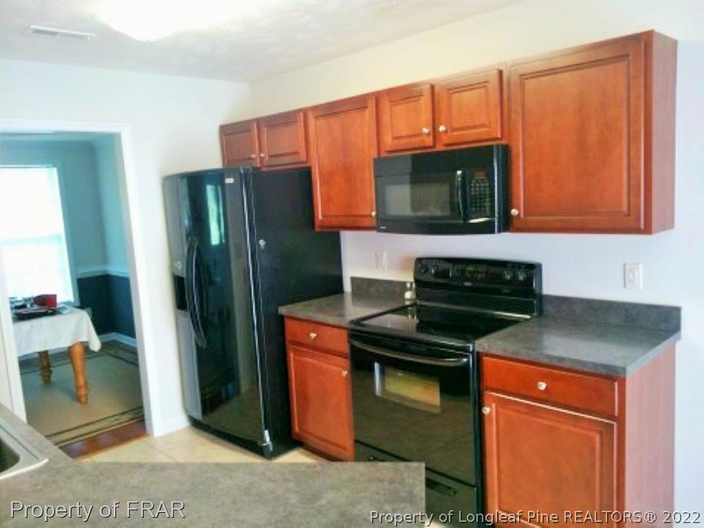 1149 Hoover Road Sanford, NC 27332 - Photo 6 of 15 a kitchen with stainless steel appliances granite countertop a refrigerator and a stove