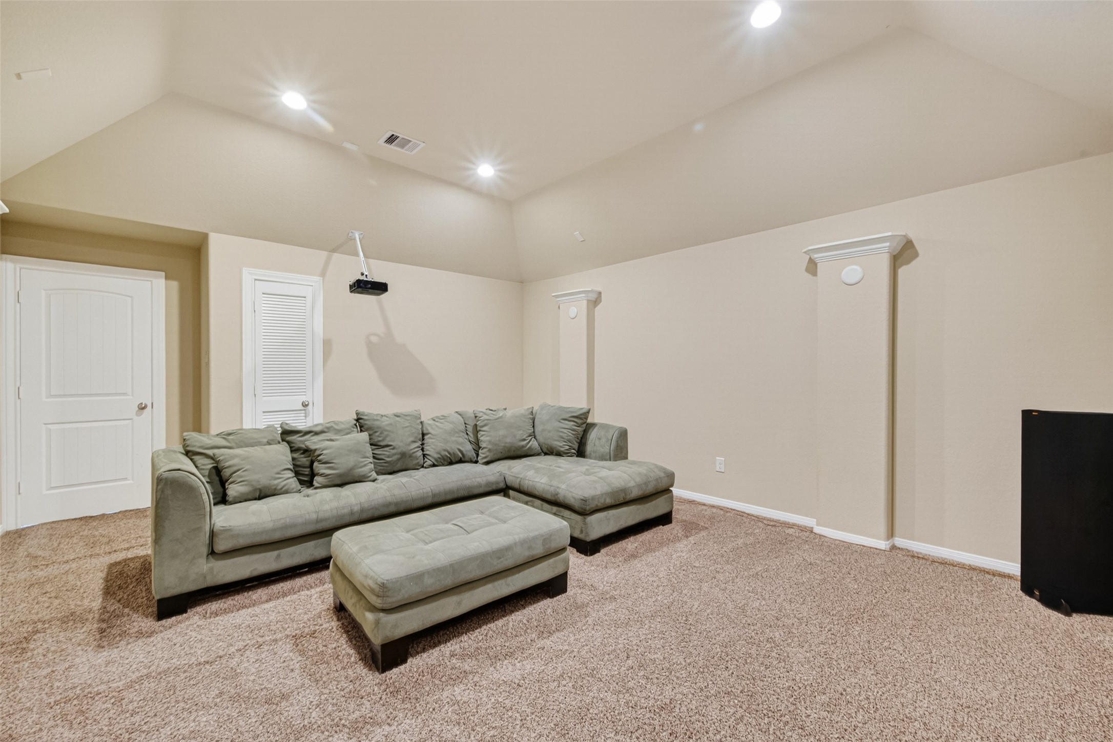 25611 Ellis Ridge Court Katy, TX 77494 - Photo 25 of 49 This spacious room features cozy carpeting, a large sectional sofa, and a mounted projector, ideal for a comfortable home theater experience.