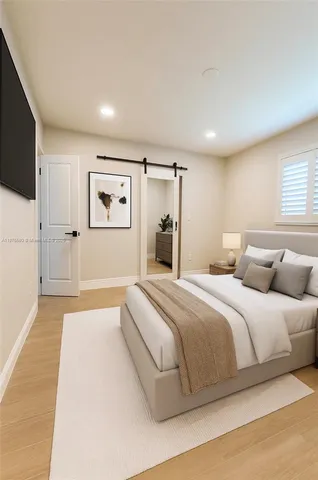 a spacious bedroom with a bed and a flat screen tv