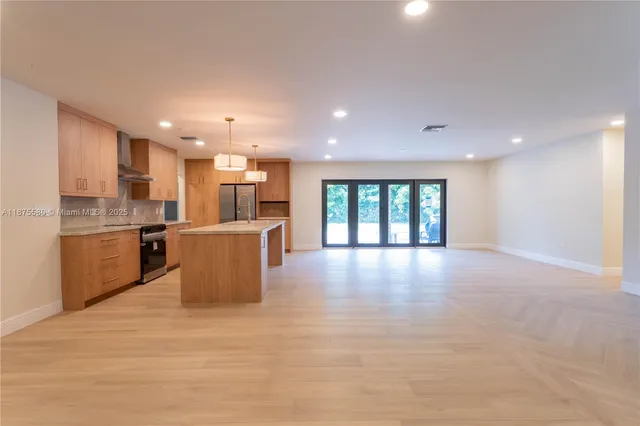 a view of kitchen with kitchen island and stainless steel appliances
