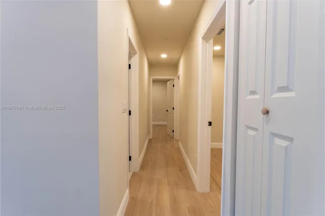 a view of a hallway with wooden floor