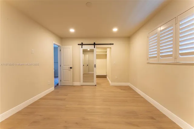 a view of empty room with wooden floor and windows