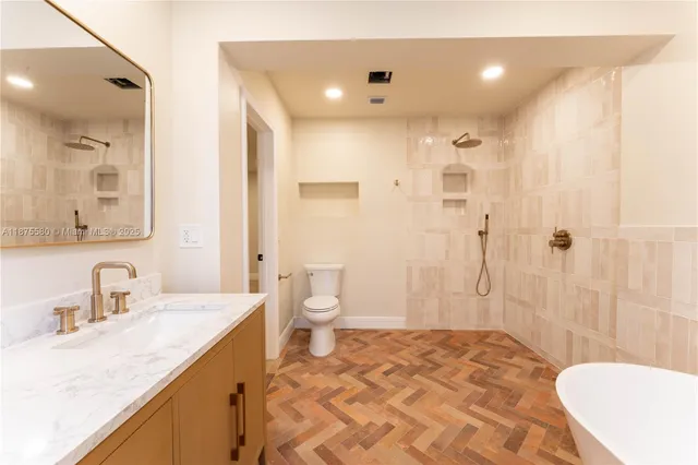 a bathroom with a sink a toilet and shower