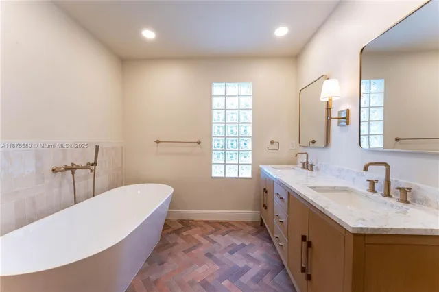 a bathroom with a tub sink and mirror