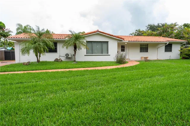 a front view of house with yard and green space