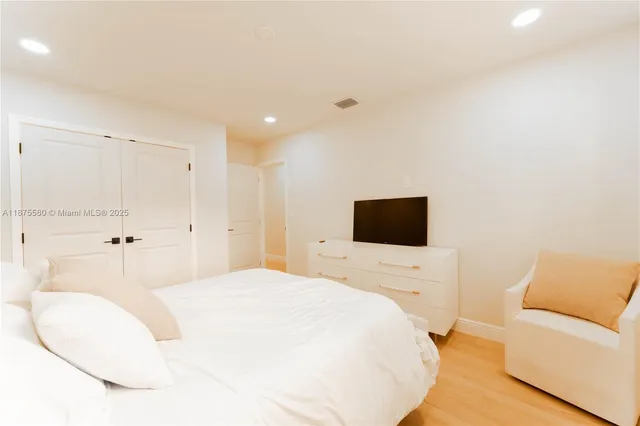 a bedroom with a bed and a flat screen tv