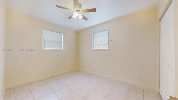 an empty room with a chandelier fan