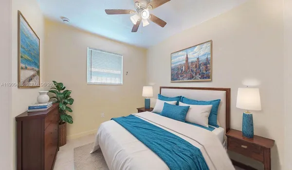 a bedroom with a bed and a lamp on a dresser