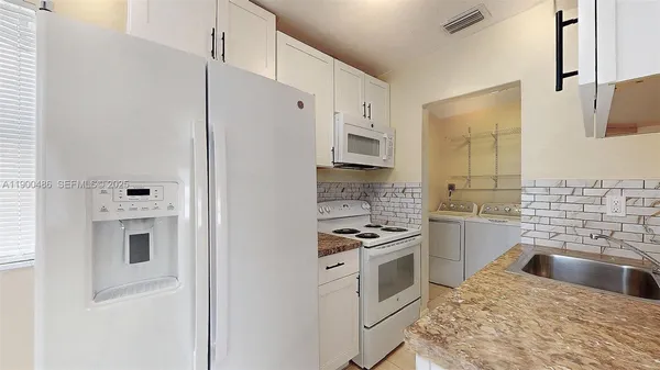 a kitchen with white cabinets and white appliances