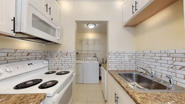 a kitchen with a sink a stove and cabinets