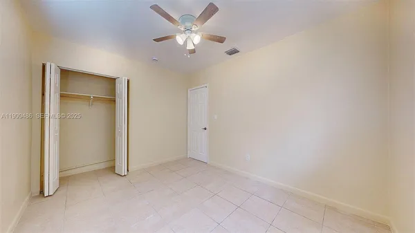 an empty room with a ceiling fan and a window