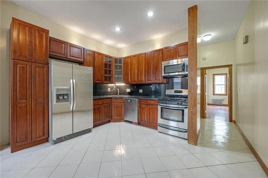 219 16th Street Brooklyn, NY 11215 - Photo 4 of 11 a kitchen with stainless steel appliances granite countertop a refrigerator and a stove top oven