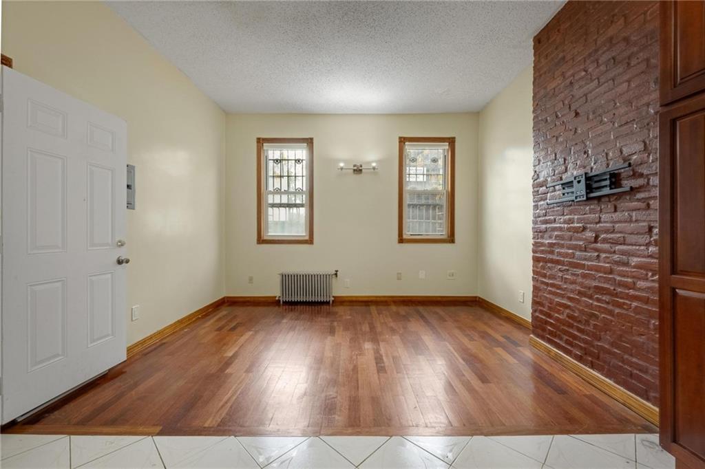 219 16th Street Brooklyn, NY 11215 - Photo 6 of 11 an empty room with wooden floor and windows
