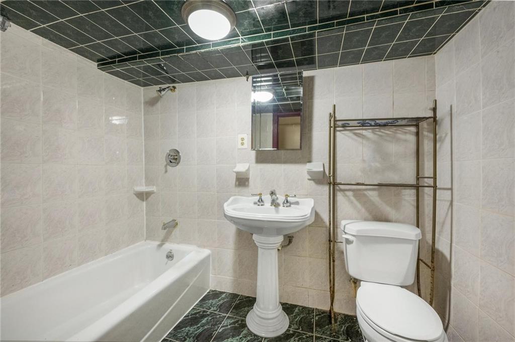 219 16th Street Brooklyn, NY 11215 - Photo 10 of 11 a bathroom with a sink toilet and shower