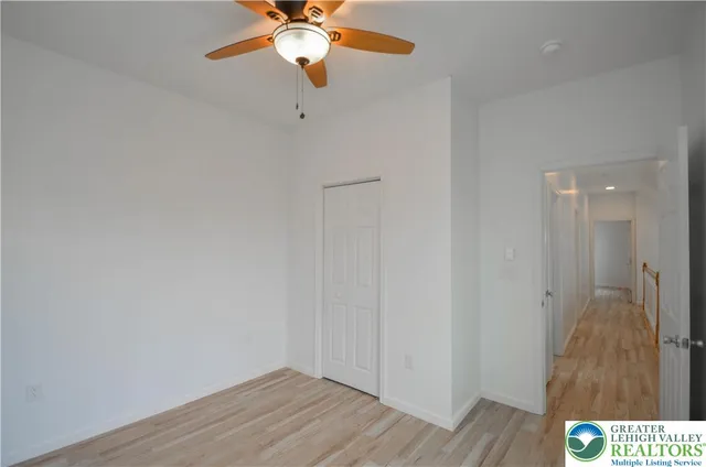 an empty room with a window and a fan