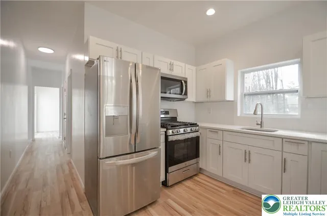 a kitchen with granite countertop a refrigerator stove and microwave
