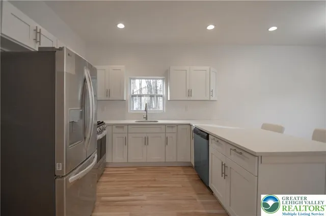 a kitchen with a sink cabinets and wooden floor