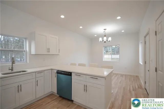 a view of a kitchen with granite countertop wooden floor and stainless steel appliances