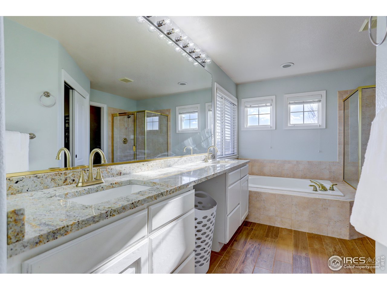 11744 Riverview Road Longmont, CO 80504 - Photo 30 of 40 a spacious bathroom with a granite countertop tub sink and mirror