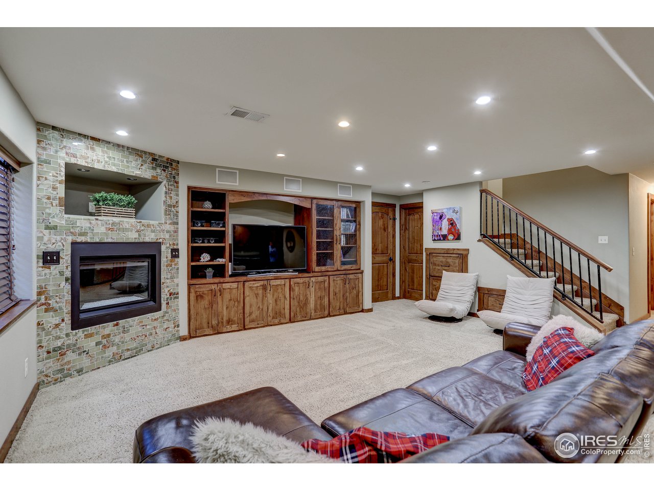 11744 Riverview Road Longmont, CO 80504 - Photo 31 of 40 a living room with furniture a flat screen tv and a fireplace