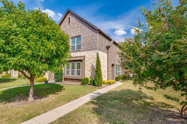 a view of a house with a yard and large tree